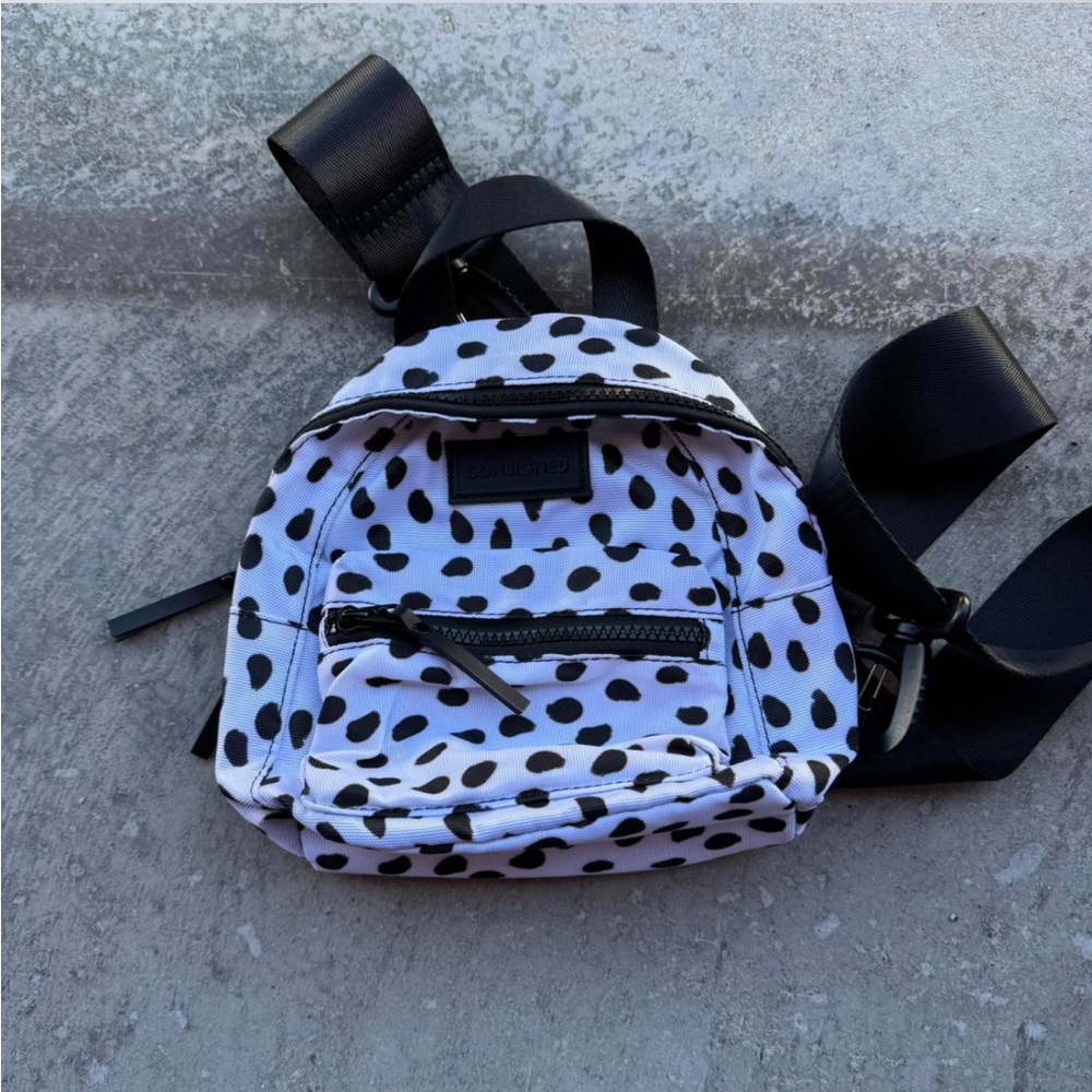 White and black mini backpack with adjustable straps. Cow print.